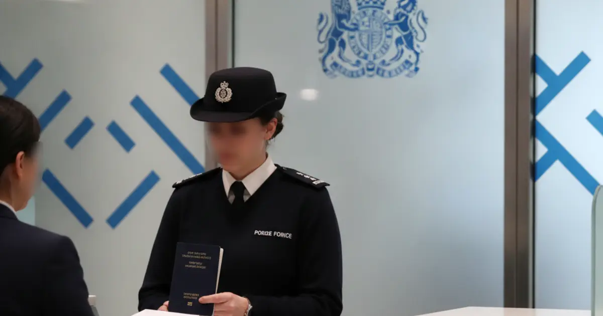 Border Force officer reviewing EU Settlement Scheme documents at a UK airport passport control desk